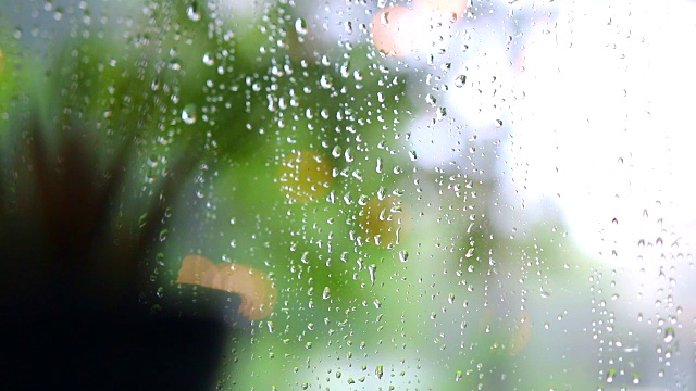 雨滴落在以花园为背景的咖啡馆的镜子上视频素材