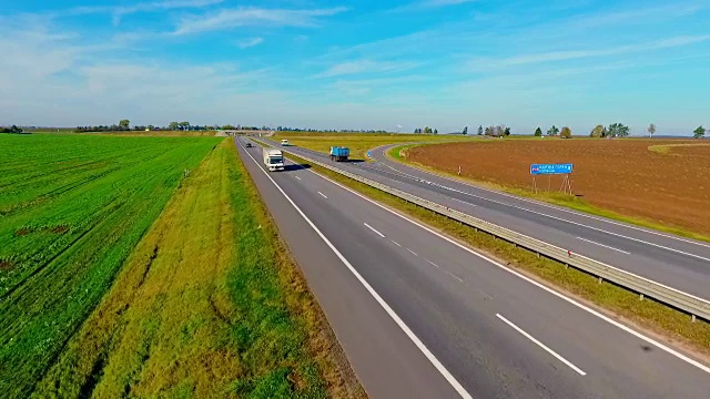 鸟瞰图卡车和汽车行驶在乡村道路上。高速公路上行驶的汽车视频素材