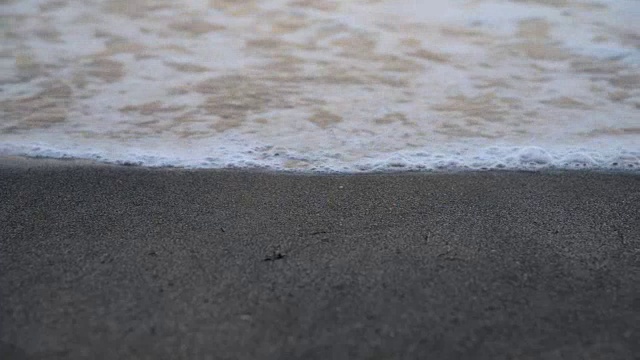 海浪卷起白色沙滩的特写镜头。视频素材