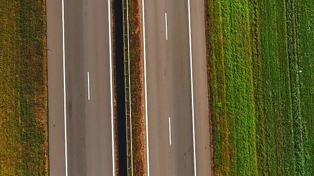 俯视图汽车在高速公路上缓慢行驶。在郊区道路上行驶的汽车视频素材