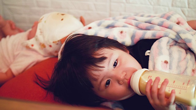 亚洲女婴用奶瓶喝牛奶视频素材