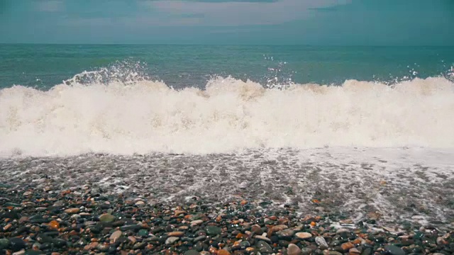 海上风暴。海浪在卵石海滩上翻滚。慢动作视频素材