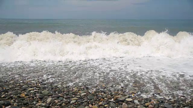 海上风暴。海浪在卵石海滩上翻滚。慢动作视频素材