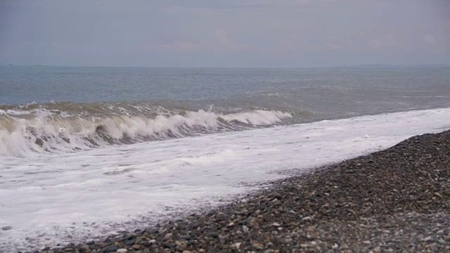 海上风暴。海浪在卵石海滩上翻滚。慢动作视频素材