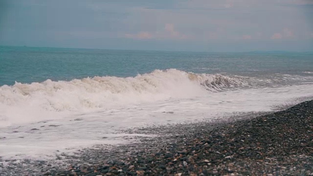 海上风暴。海浪在卵石海滩上翻滚。慢动作视频素材