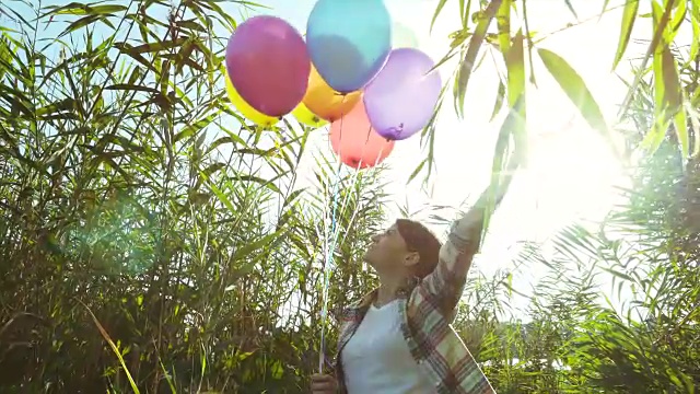 一个女人在玩一堆气球。视频素材