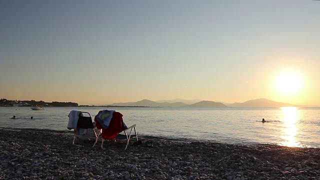 两个座位旁边的躺椅紧挨着海岸线，沙滩视频素材