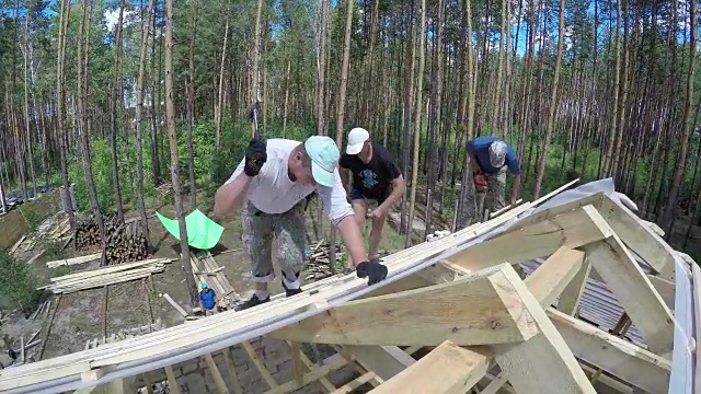 屋顶工人正在把钉子钉进屋顶的木板里。视频素材