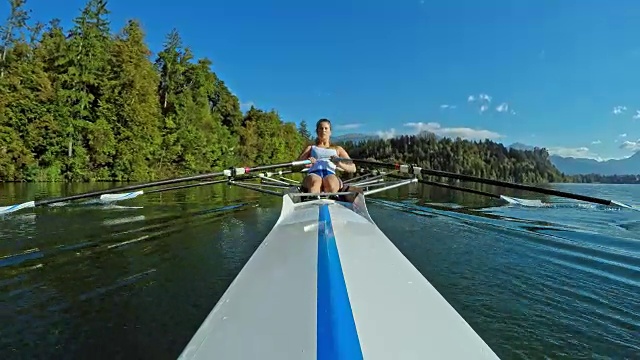 女运动员在阳光明媚的湖面上进行双桨划水视频素材