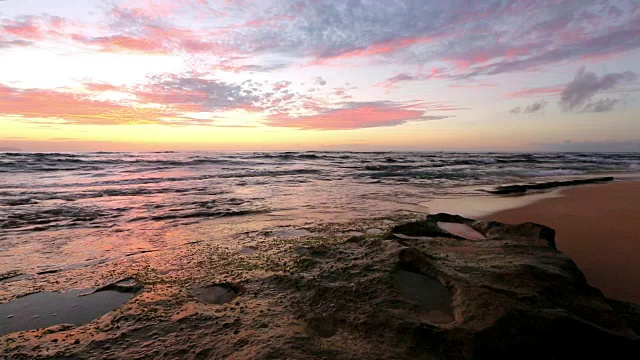 海浪拍打着夏威夷瓦胡岛日落海滩附近的岩石视频素材