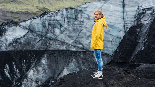 女游客正在欣赏被火山灰覆盖的冰川视频素材