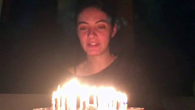 女人吹生日蛋糕。年轻女子庆祝她的30岁生日视频素材