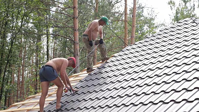 屋顶工人在屋顶上工作。视频素材