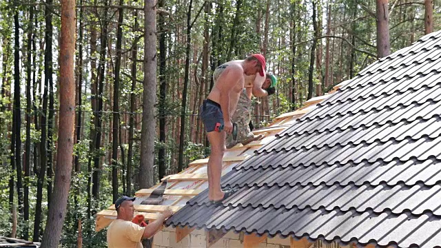 屋顶工人在屋顶上工作。视频素材