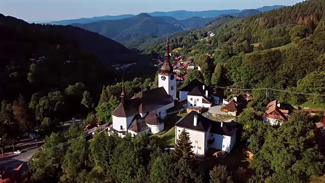 在斯洛伐克风景如画的历史村庄Spania Dolina上空飞过坚固的教堂视频素材