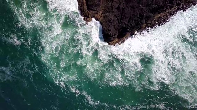 空中上升从上到下的观点打破海浪沿岩石海岸视频素材