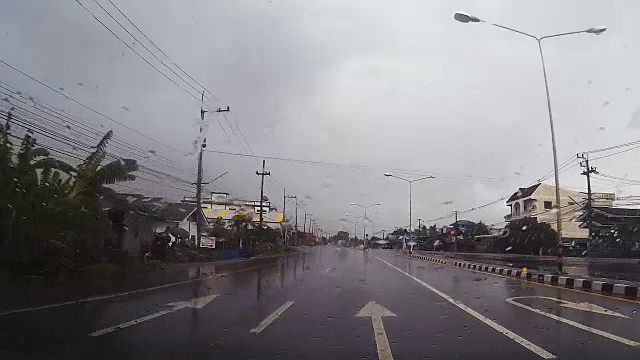 透过汽车挡风玻璃看路，有雨滴，在雨中行驶。视频素材