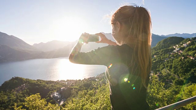 女人拍摄的湖和湖滨村庄的全景照片视频素材