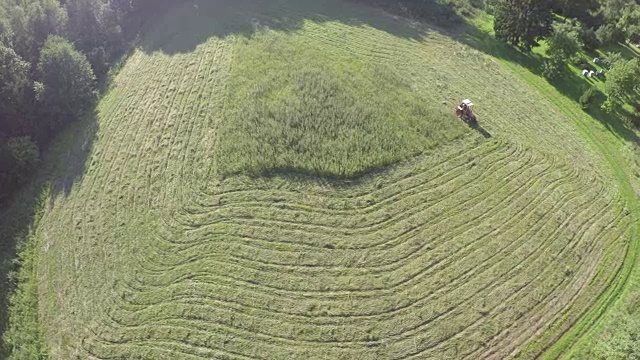 老拖拉机从夏季草地干草，鸟瞰图视频素材