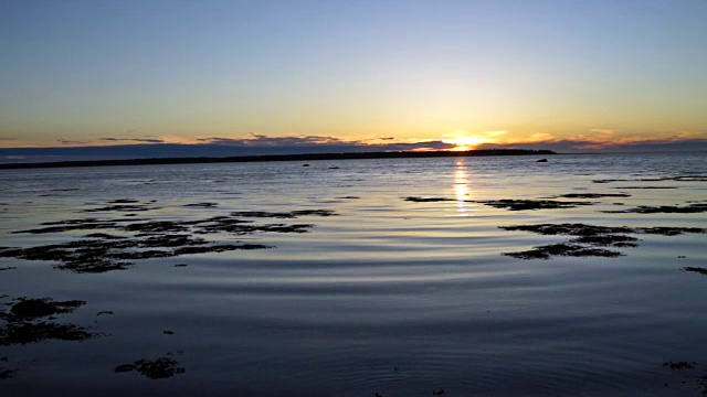 蓝色和紫色的日落在Rimouski，魁北克的圣劳伦斯河在加斯比西地区的加拿大海岸和海浪的特写视频素材