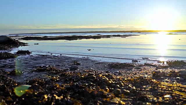 日落在Rimouski，魁北克省的圣劳伦斯河在加斯比西地区的加拿大海岸，自然，遥远的岛屿，岩石和海浪的特写视频素材