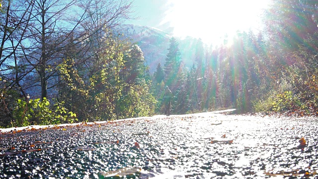 骑山地车的人沿着潮湿的道路走向阳光视频素材