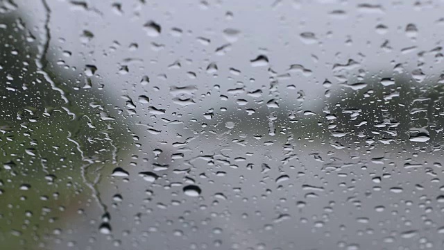 雨点与道路一起落在挡风玻璃上。视频素材