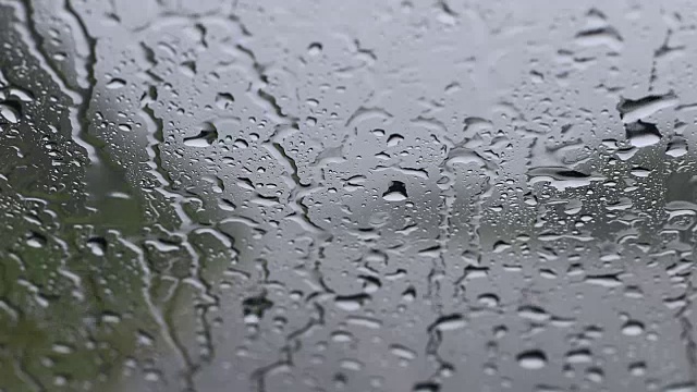 雨点与道路一起落在挡风玻璃上。视频素材