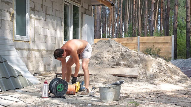 建筑工人在桶里搅拌水泥和水。视频素材