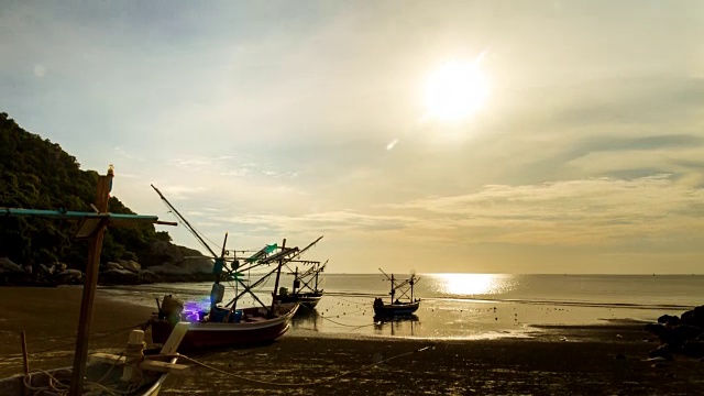 美丽的时光流逝，海滩上的渔船和海面上的太阳视频素材