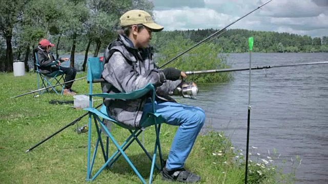 孩子在钓鱼。在湖上休息视频素材