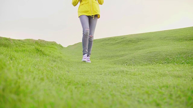 低角度的年轻女子徒步在草地景观视频素材