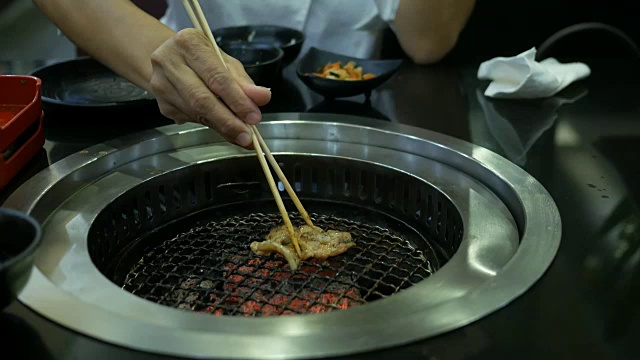 女人的手用筷子夹烤猪肉视频素材