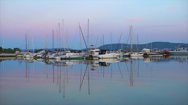 宁静的海景，黄昏时分，港口里有一艘低垂的小游艇视频素材