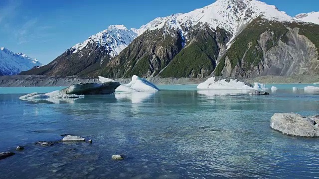 冰山漂浮在冰川泻湖与雪山的背景视频素材