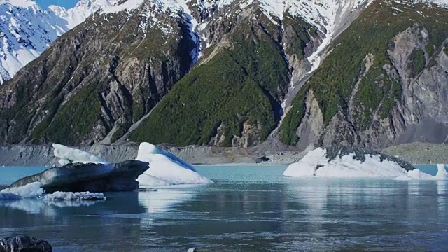 冰山漂浮在冰川泻湖与雪山的背景视频素材