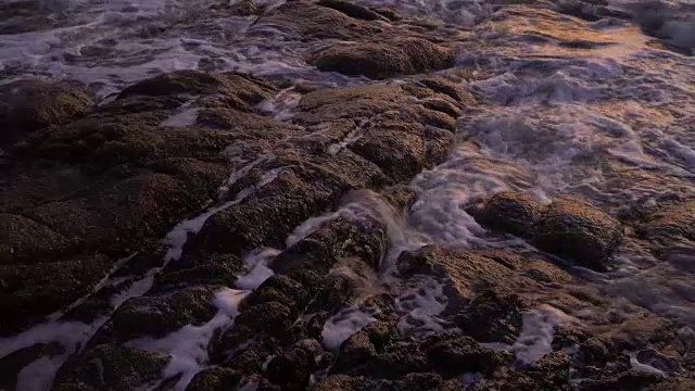 4k特写的海滩和石头与日落。视频素材