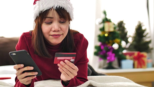 有个女人在圣诞节用信用卡用手机网购视频素材