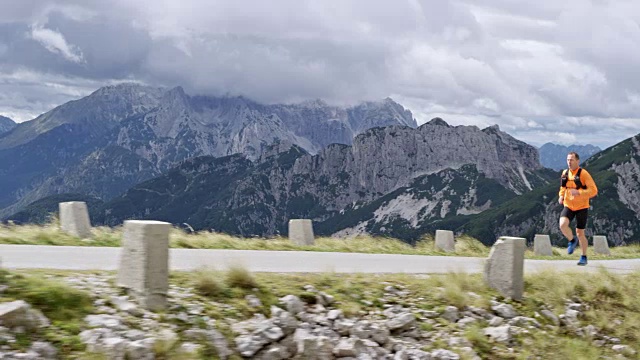 SLO MO DS男子在阳光下的山路上跑步视频素材