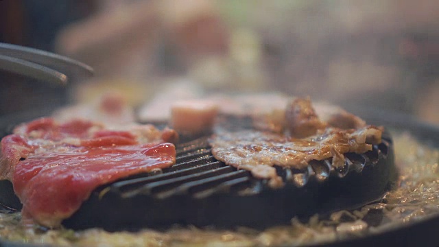 在炉子上烤烤肉。关闭牛肉烤在日本餐厅。用于烧烤或日式食物的生牛肉片视频素材