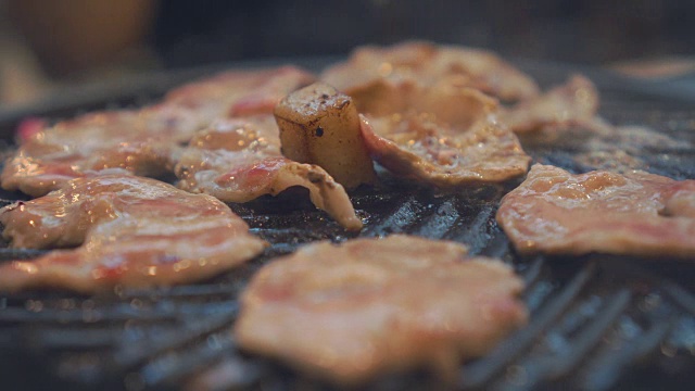 在炉子上烤烤肉。关闭牛肉烤在日本餐厅。用于烧烤或日式食物的生牛肉片视频素材