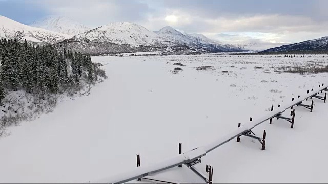 阿拉斯加输油管道穿越崎岖的山脉景观视频素材