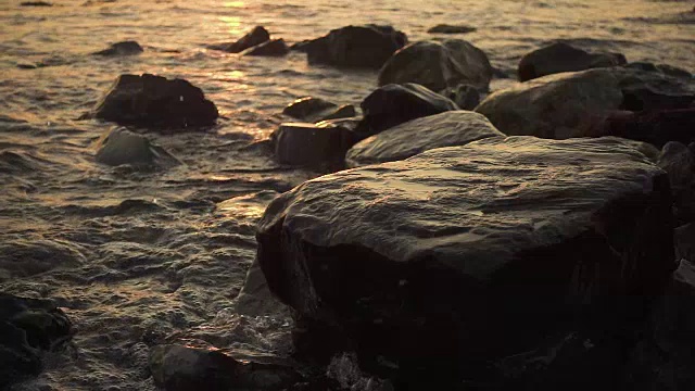 慢动作浪花溅在岸边的岩石上视频素材