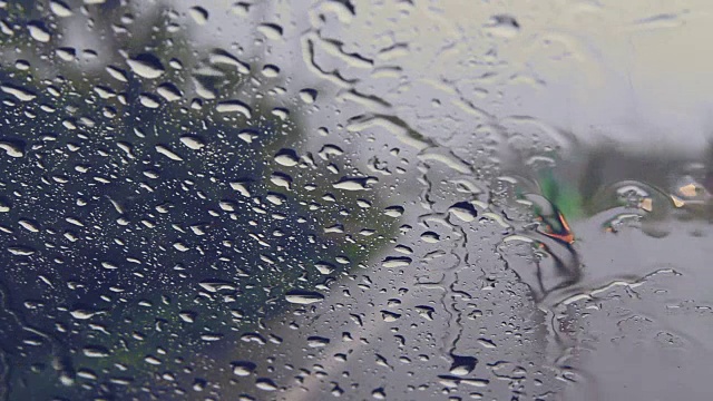 透过汽车挡风玻璃看路，有雨滴，在雨中行驶。视频素材