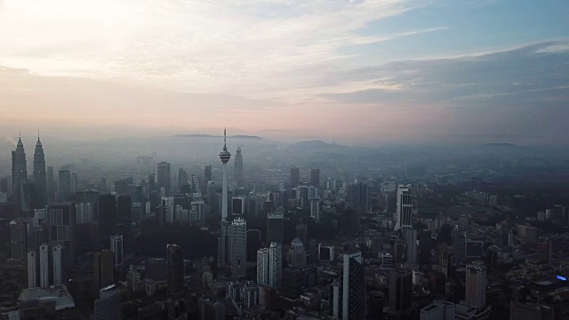 燃烧的天空映衬着吉隆坡摩天大楼与雾和薄雾的早晨。视频素材