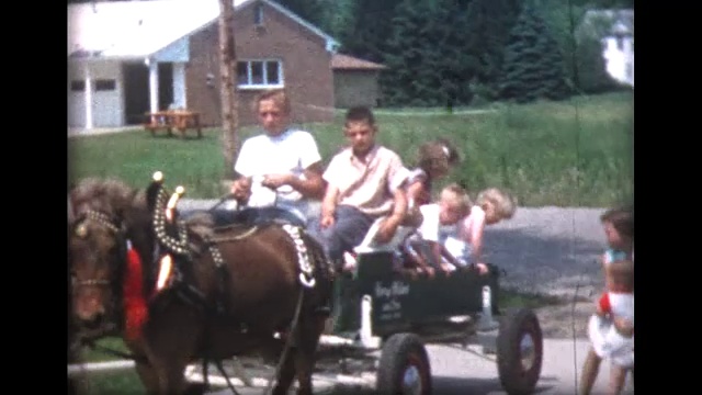 1959年，孩子们在生日派对上骑着小马车视频素材