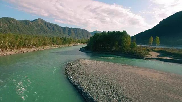 全高清FHD鸟瞰图。在阳光明媚的夏日清晨，低空飞过新鲜寒冷的山间河流。绿树和阳光洒在地平线上视频素材