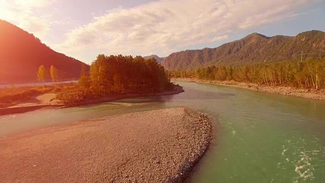 全高清FHD鸟瞰图。在阳光明媚的夏日清晨，低空飞过新鲜寒冷的山间河流。绿树和阳光洒在地平线上视频素材