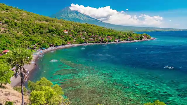 以印度尼西亚巴厘岛阿贡火山为背景的海湾中漂浮着的船只。视频素材