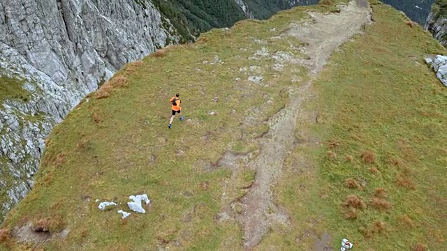 空中奔跑者在山脊的尽头停下来，双手举在空中视频素材